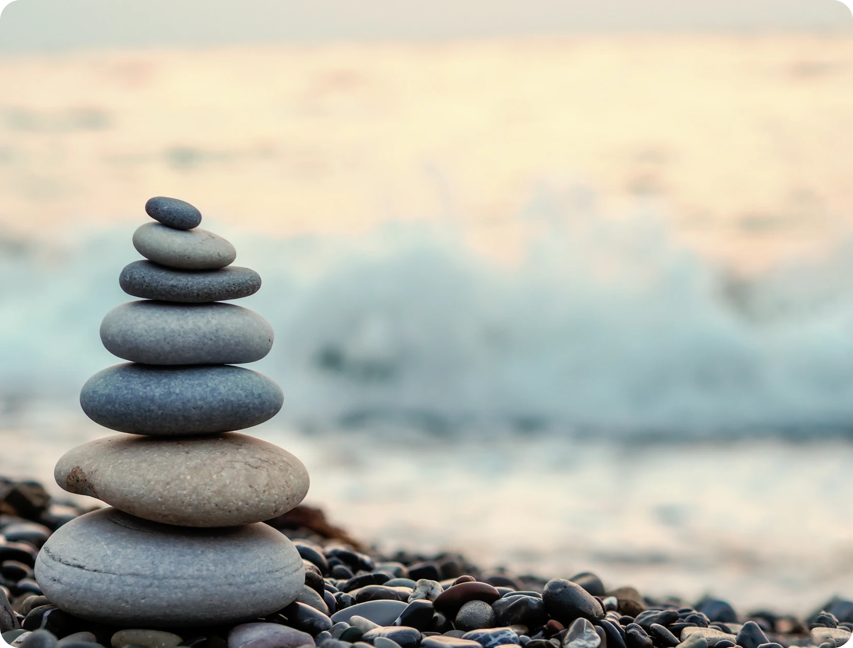 Balanced stones by the ocean waves