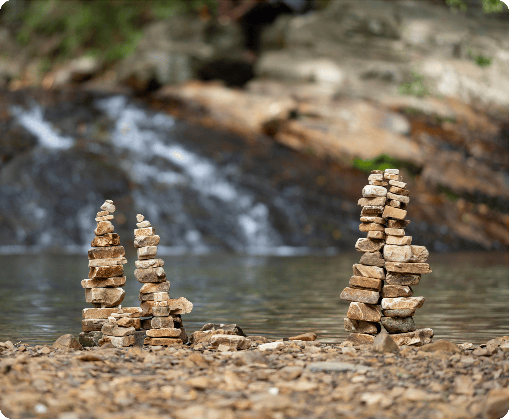 Stone cairns in front of waterfall